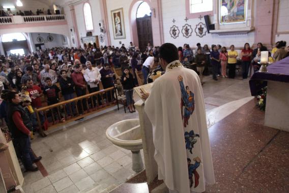 Catholic priest Alvarez officiates mass while wearing a robe with the images of cartoon characters Superman and Batman at the Ojo de Agua church in Saltillo